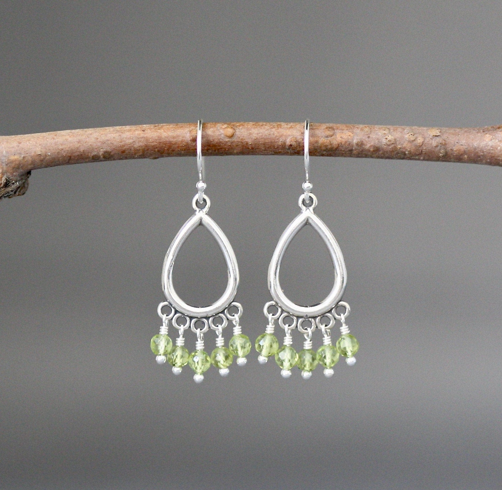 Peridot chandelier earrings with silver teardrop hoops and five green stones, dangle