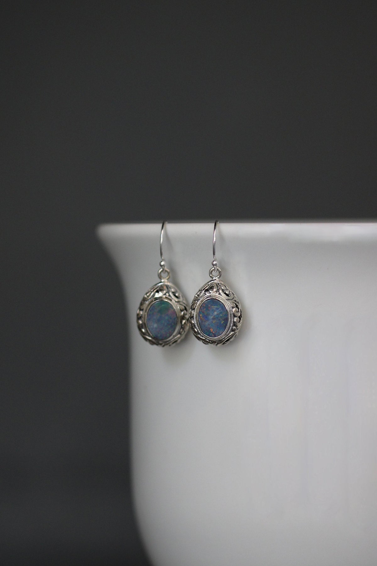 Sterling silver dangle earrings with round blue opal cabochons and ornate filigree drops