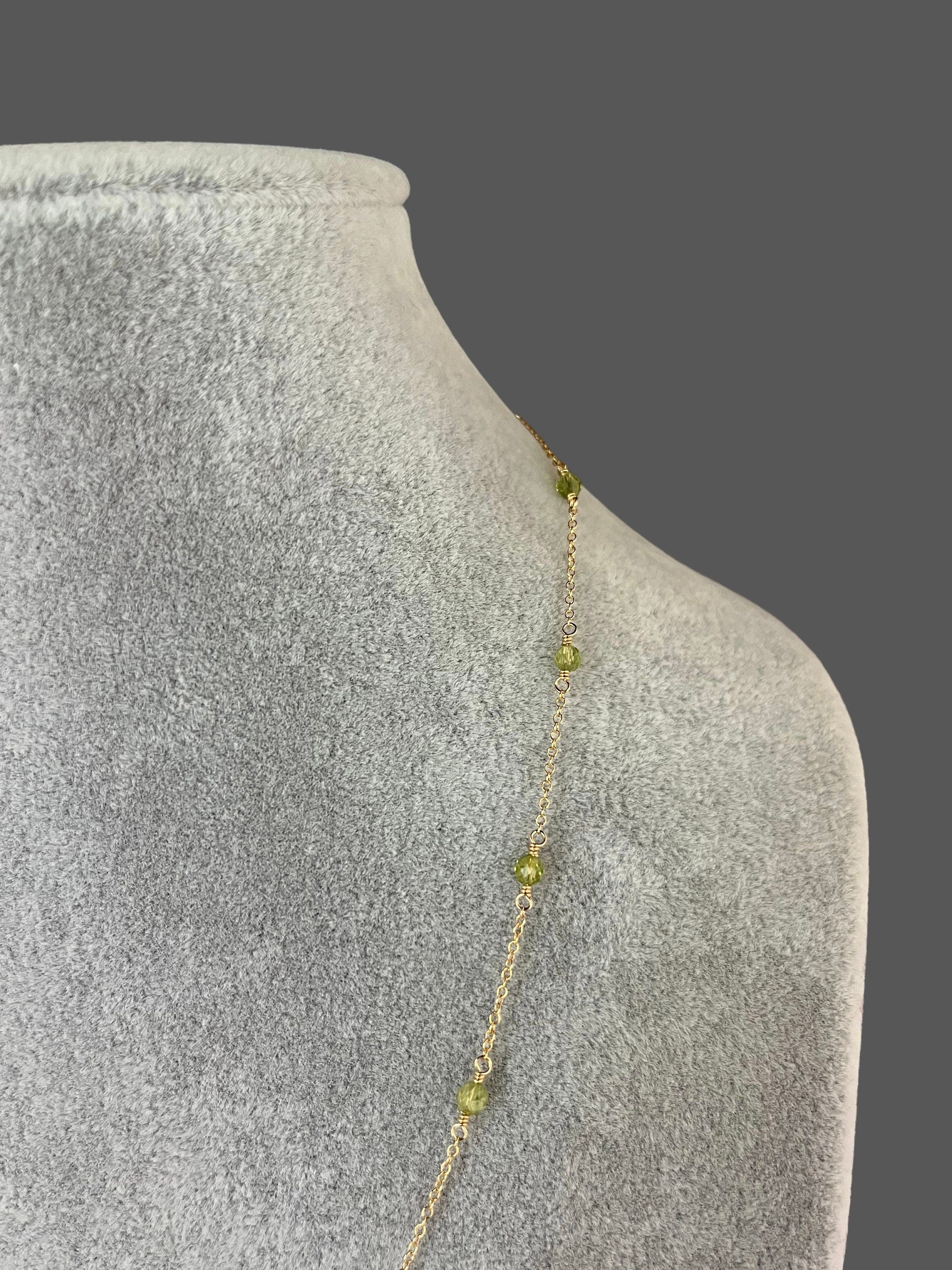 Fine gold chain necklace with small round green peridot stones