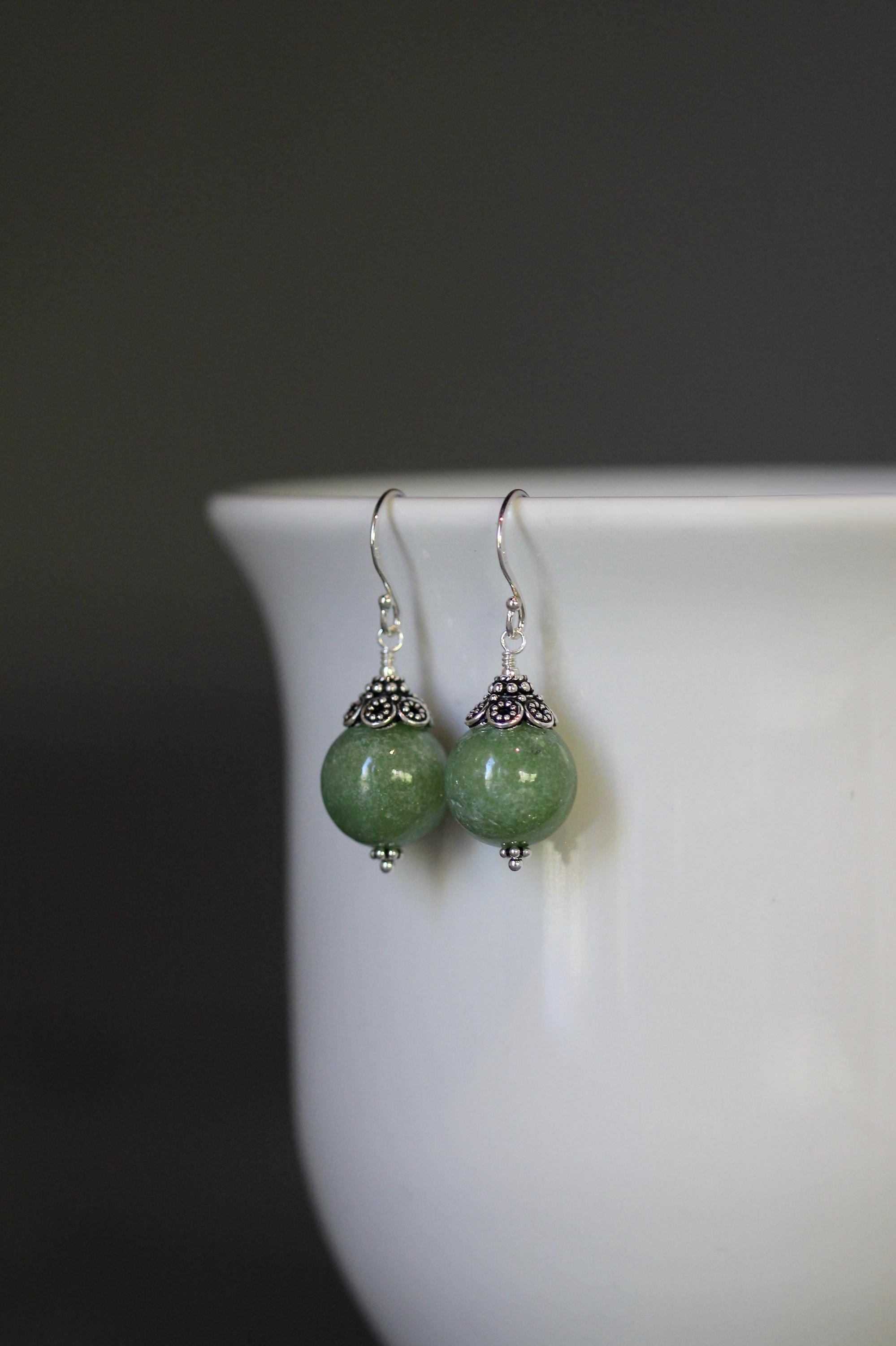 Green jade round dangle earrings with sterling silver caps and ornate bead details