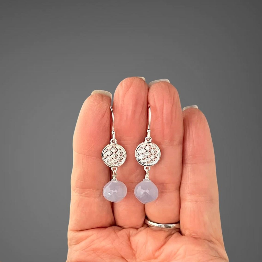 Sterling silver drop earrings with round filigree discs and blue chalcedony drops, on hand