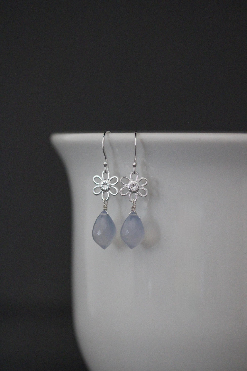 Sterling silver earrings with blue teardrop charms and flower top links