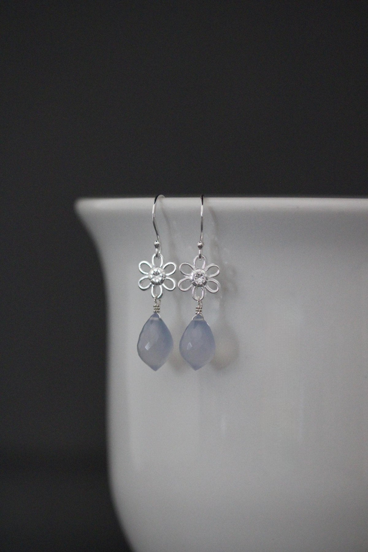 Sterling silver earrings with blue teardrop charms and flower top links