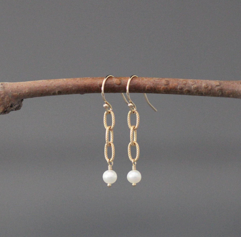 Gold hoop earrings with linked chain drops and small white freshwater pearls.