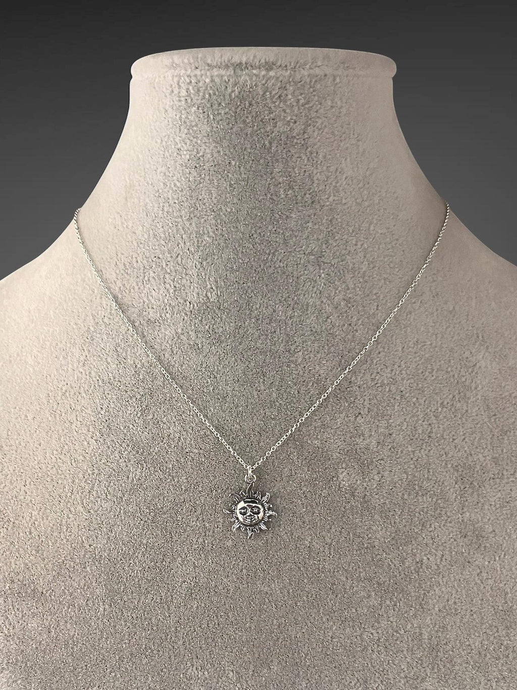 Sterling silver sun pendant necklace with round sun charm at center on chain
