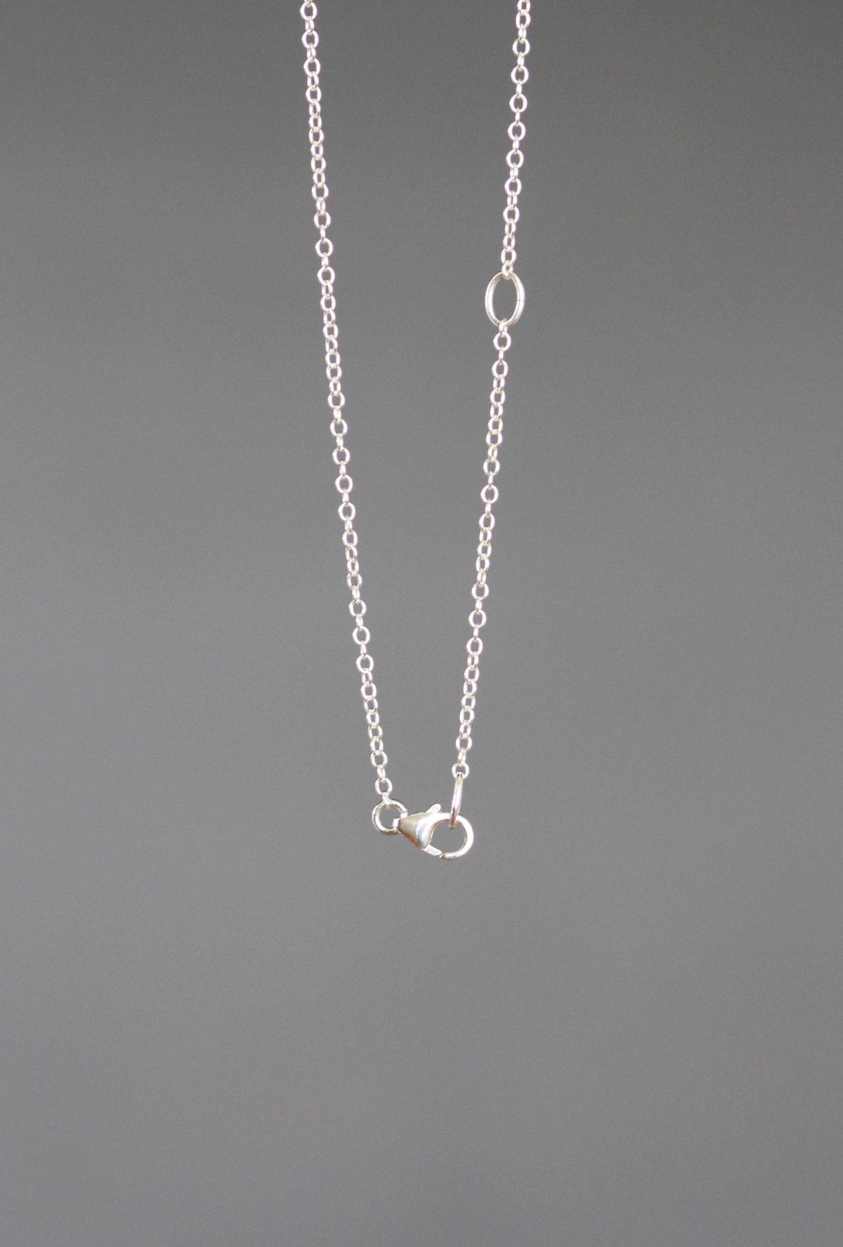 Sterling silver chain necklace with small sun pendant and lobster-style clasp