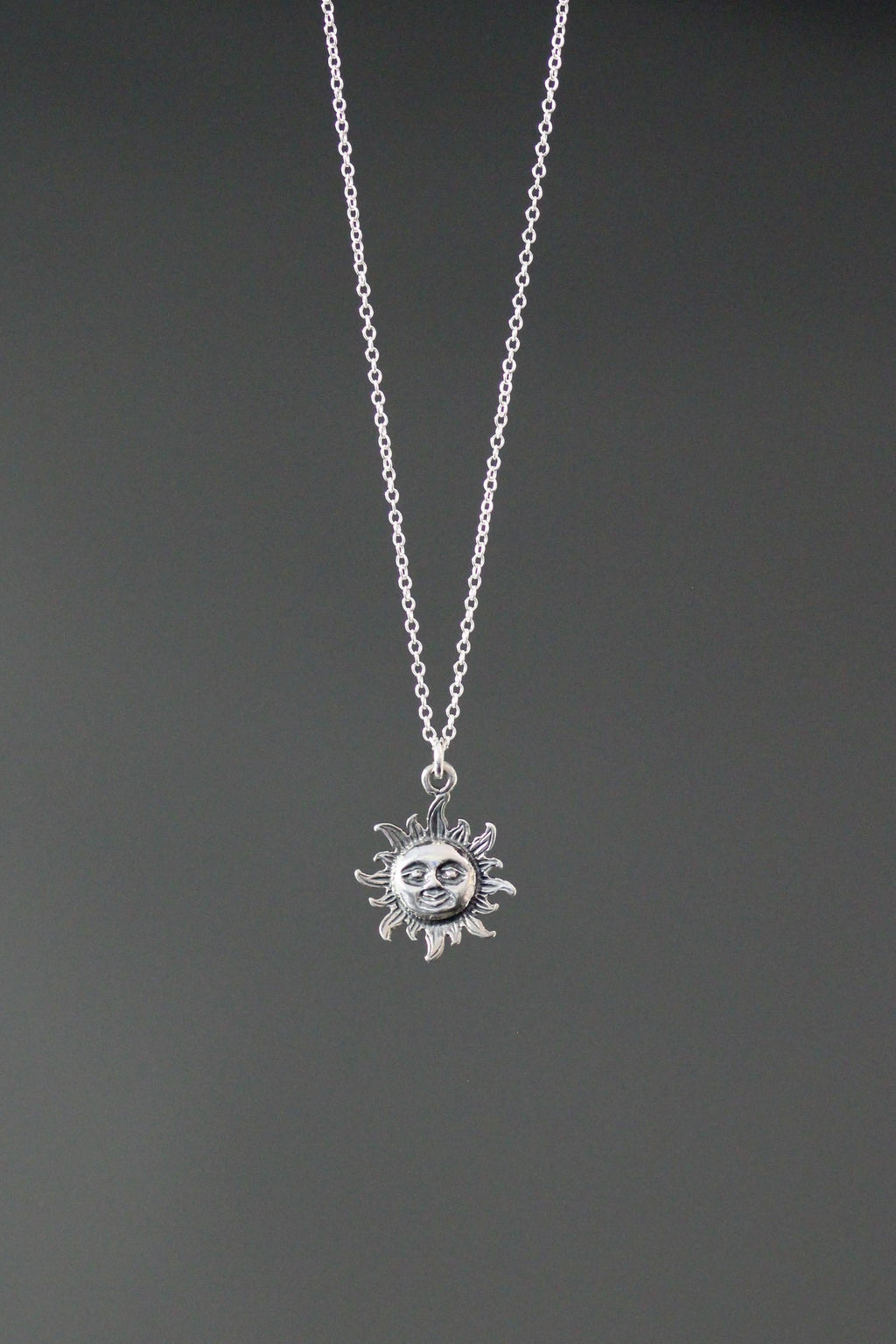 Sterling silver sun pendant necklace with round sun charm centered on chain