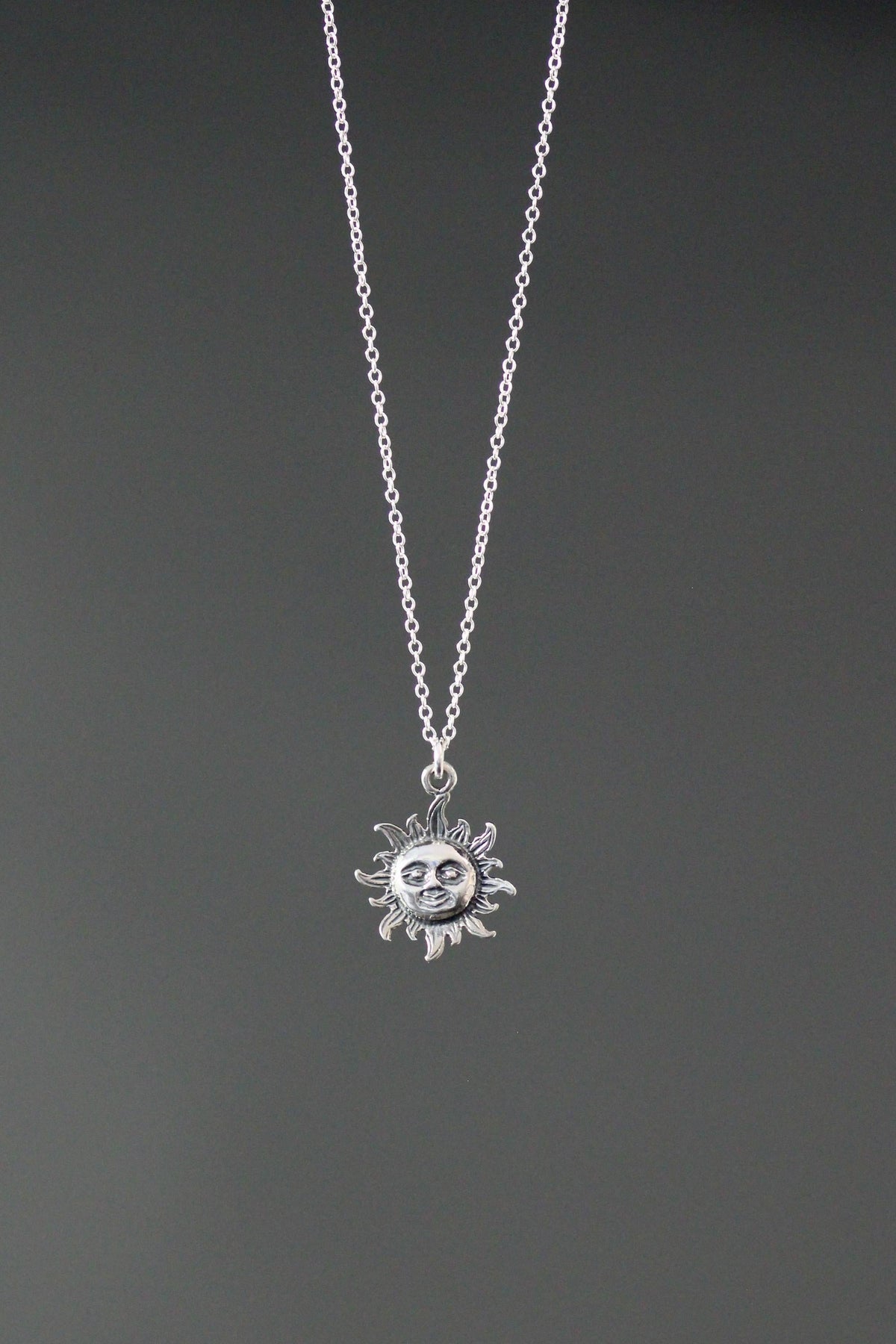 Sterling silver sun pendant necklace with round sun charm centered on chain