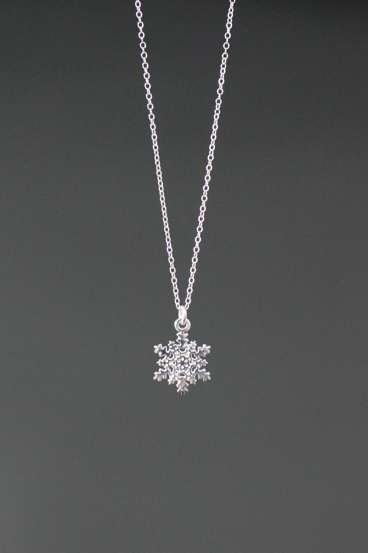 Sterling silver snowflake charm necklace with detailed snowflake pendant