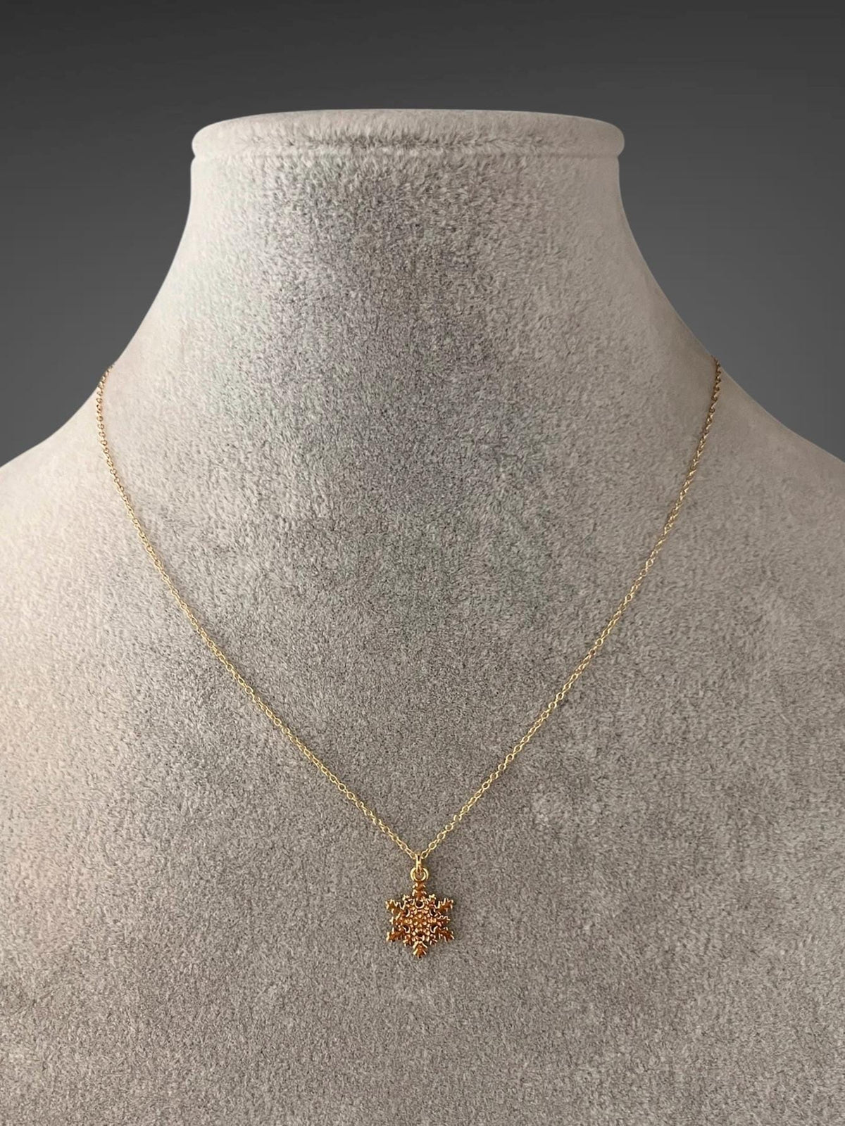 Gold vermeil snowflake pendant necklace displayed on a bust
