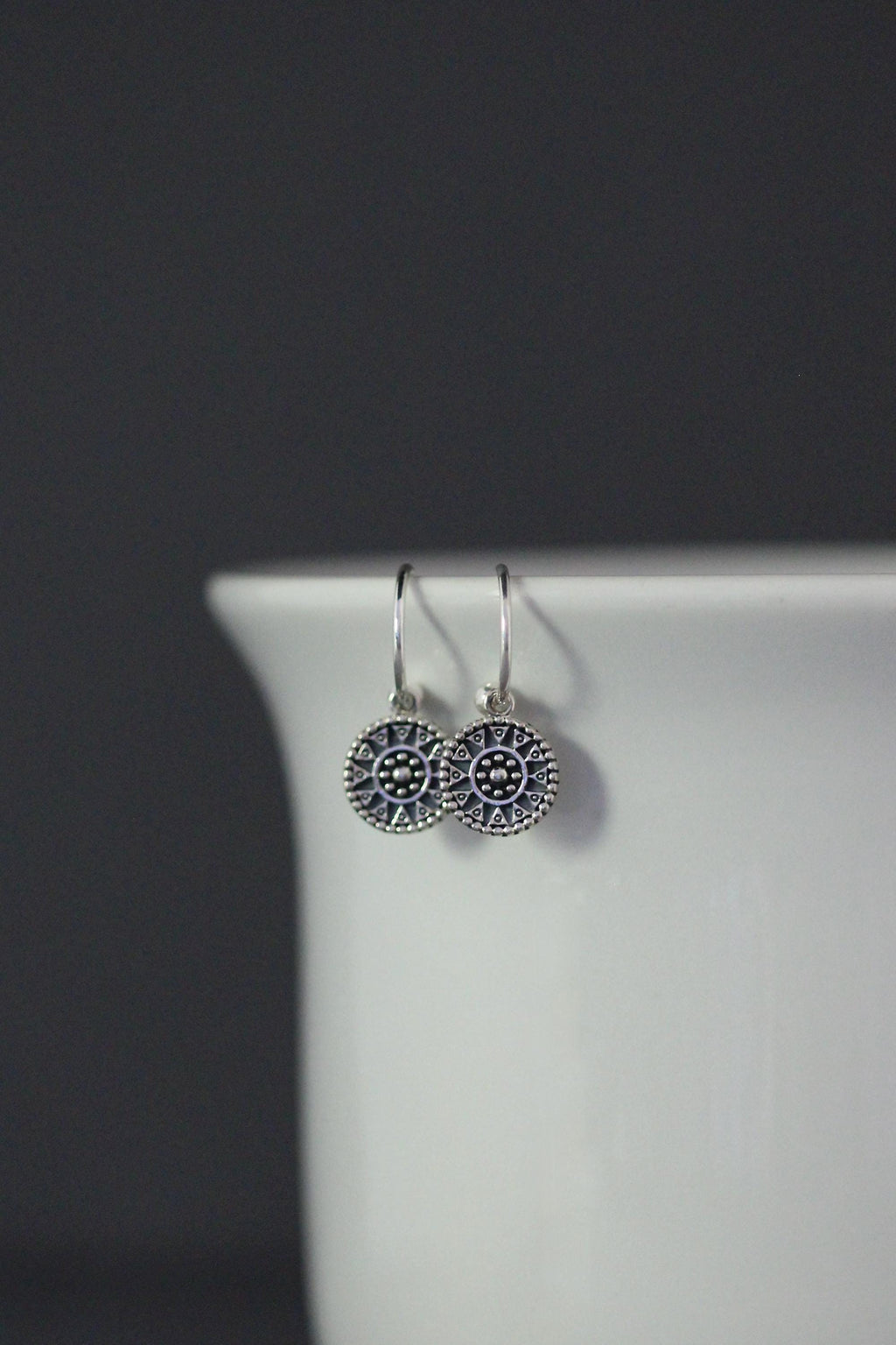 Sterling silver medallion charm earrings with ornate dotted faces and fishhook wires