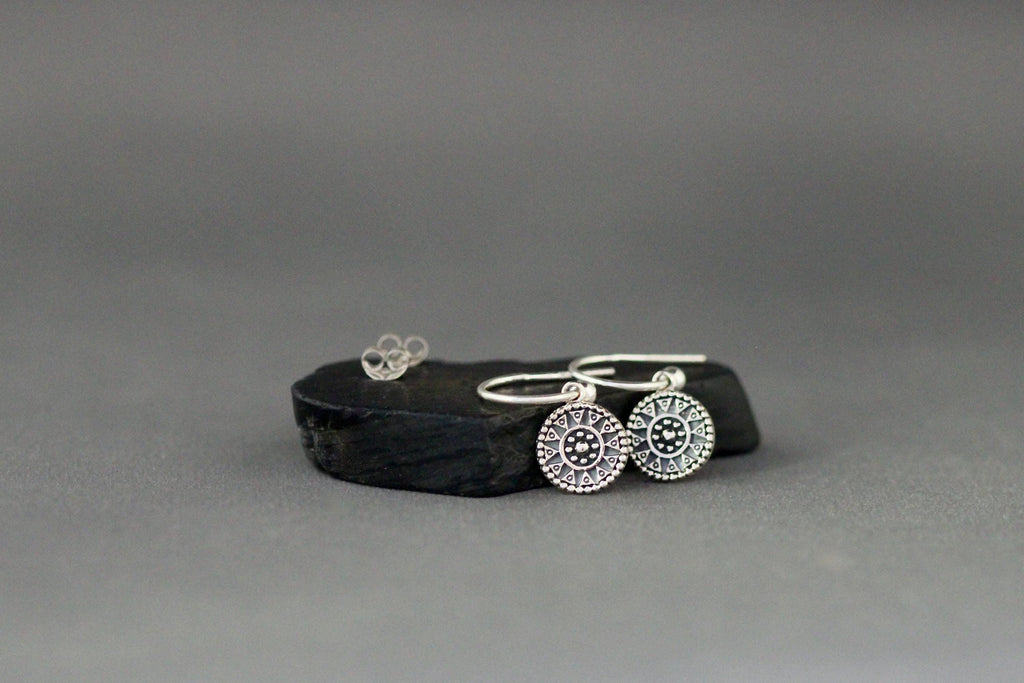 Sterling silver medallion charm earrings with circular patterned charms and hook closures