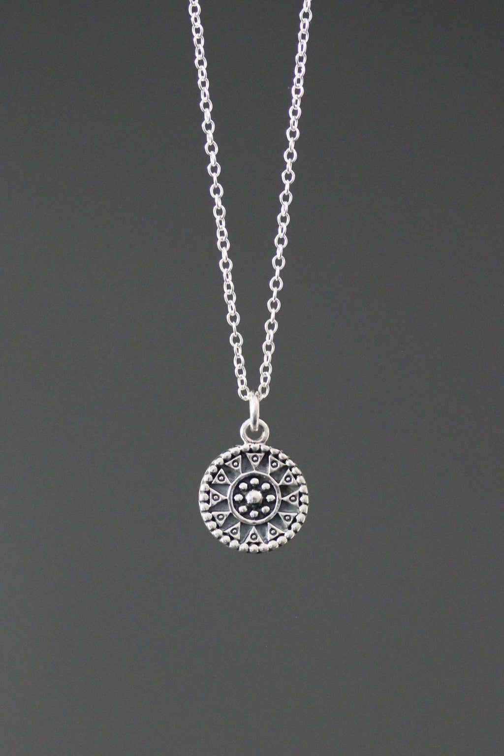 Sterling silver medallion charm necklace with an ornate round pendant and fine chain