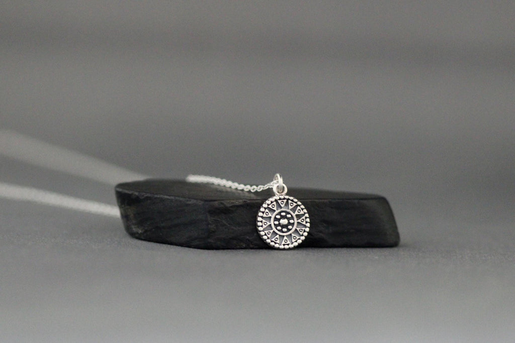 Sterling silver medallion charm necklace showing the detailed round pendant