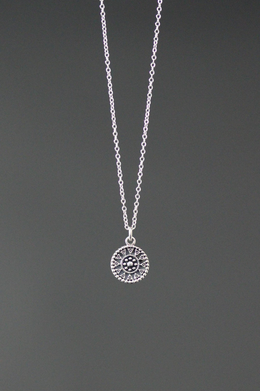 Sterling silver medallion charm necklace with a patterned circular pendant