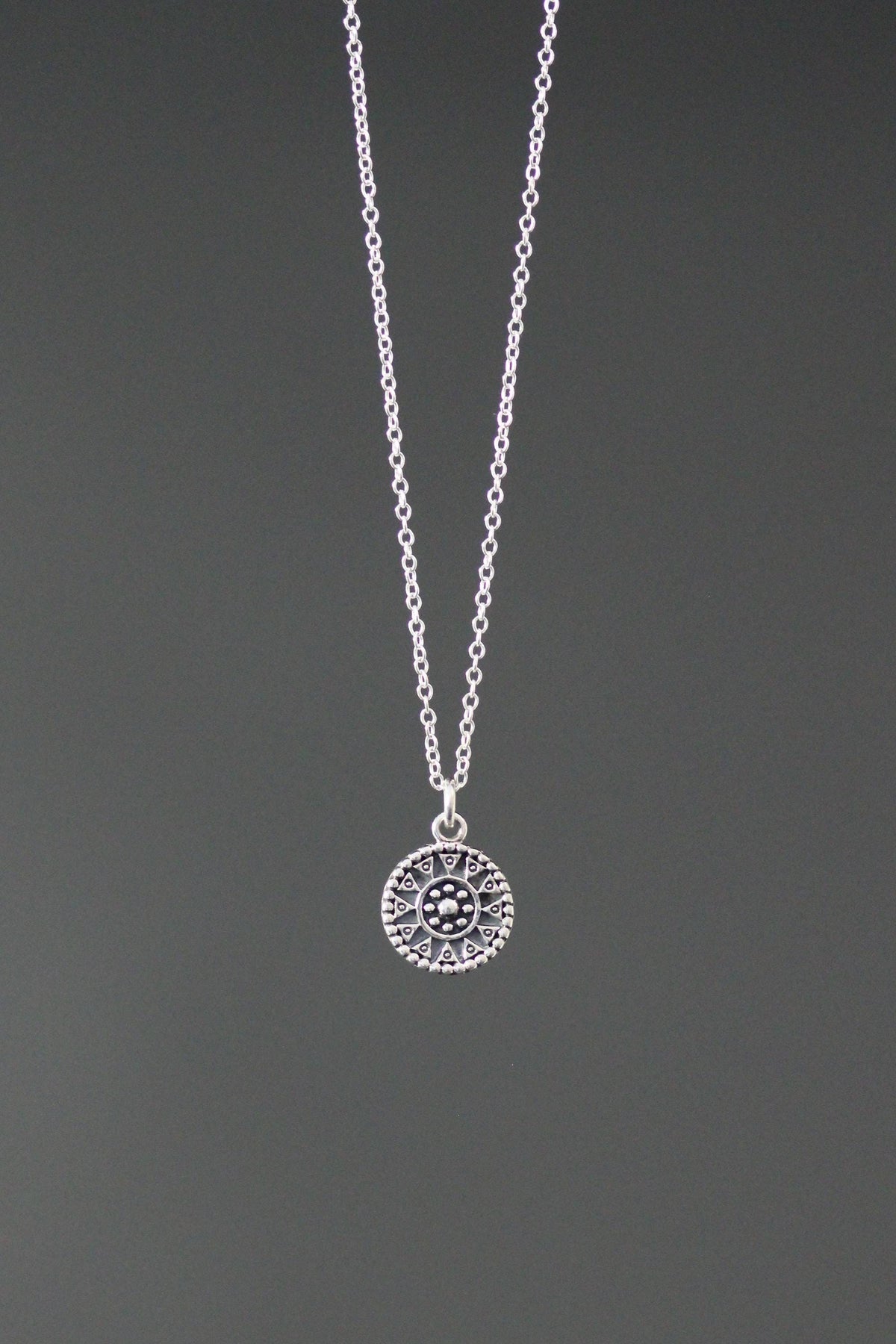 Sterling silver medallion charm necklace with a patterned circular pendant