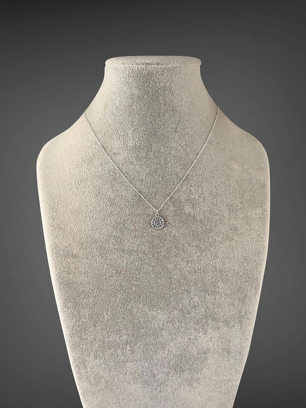 Sterling silver necklace with a delicate chain and small medallion pendant
