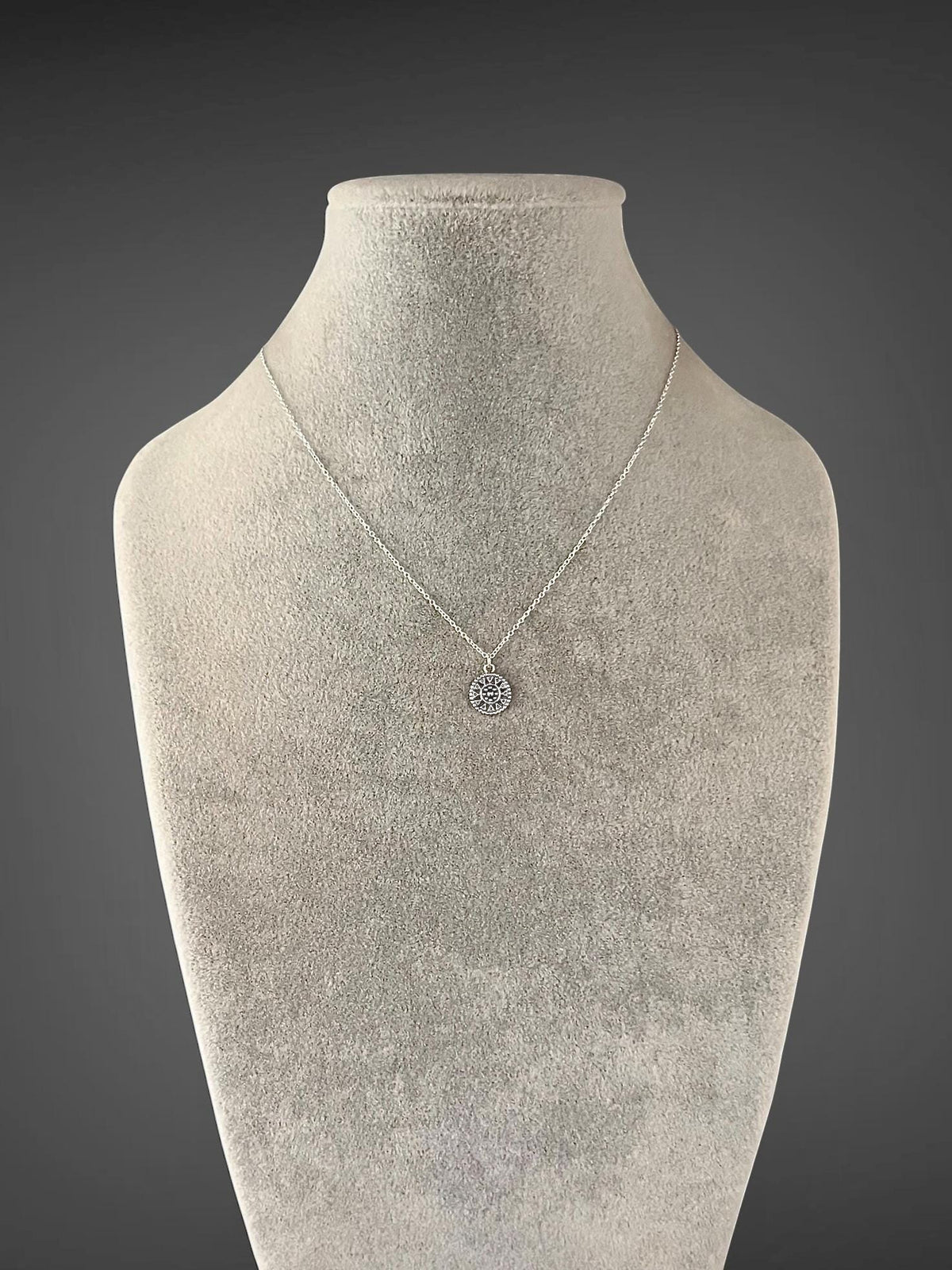 Sterling silver necklace with a delicate chain and small medallion pendant