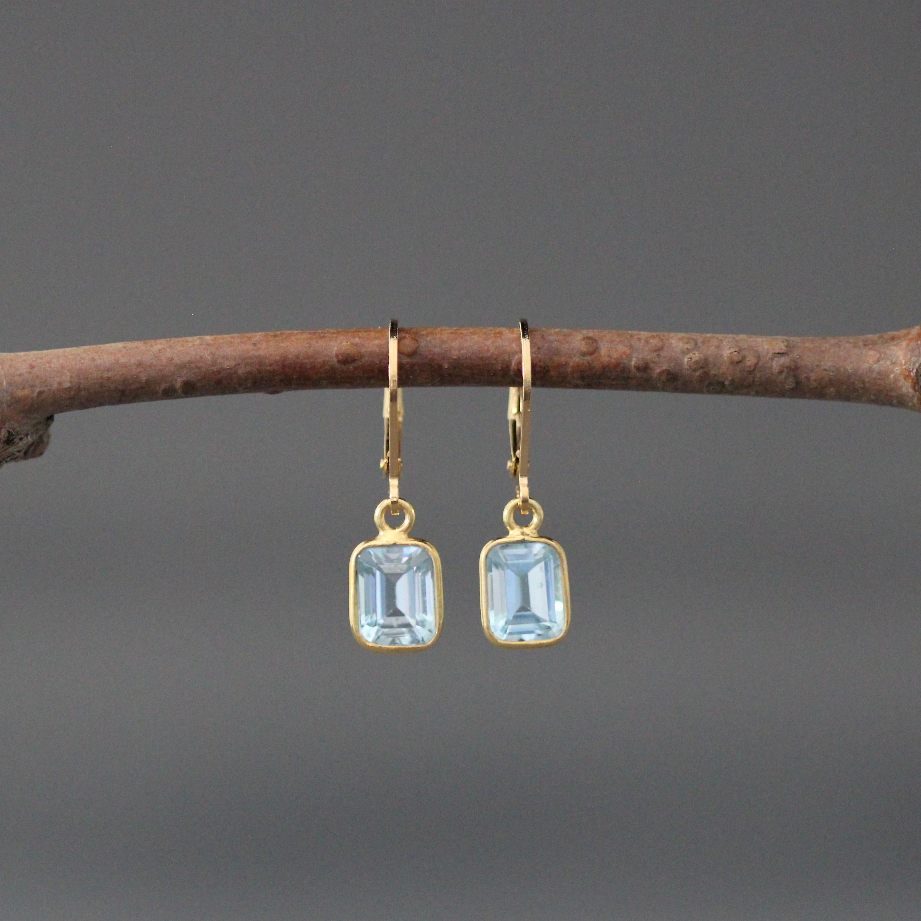 Gold vermeil leverback earrings with light blue emerald-cut stones in bezel settings