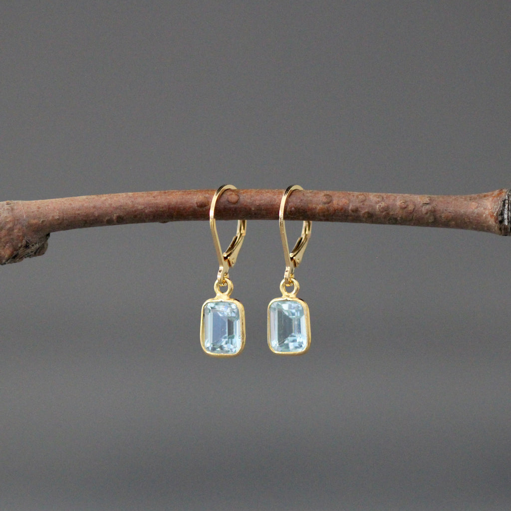 Gold vermeil leverback earrings with two light blue emerald-cut stone charms