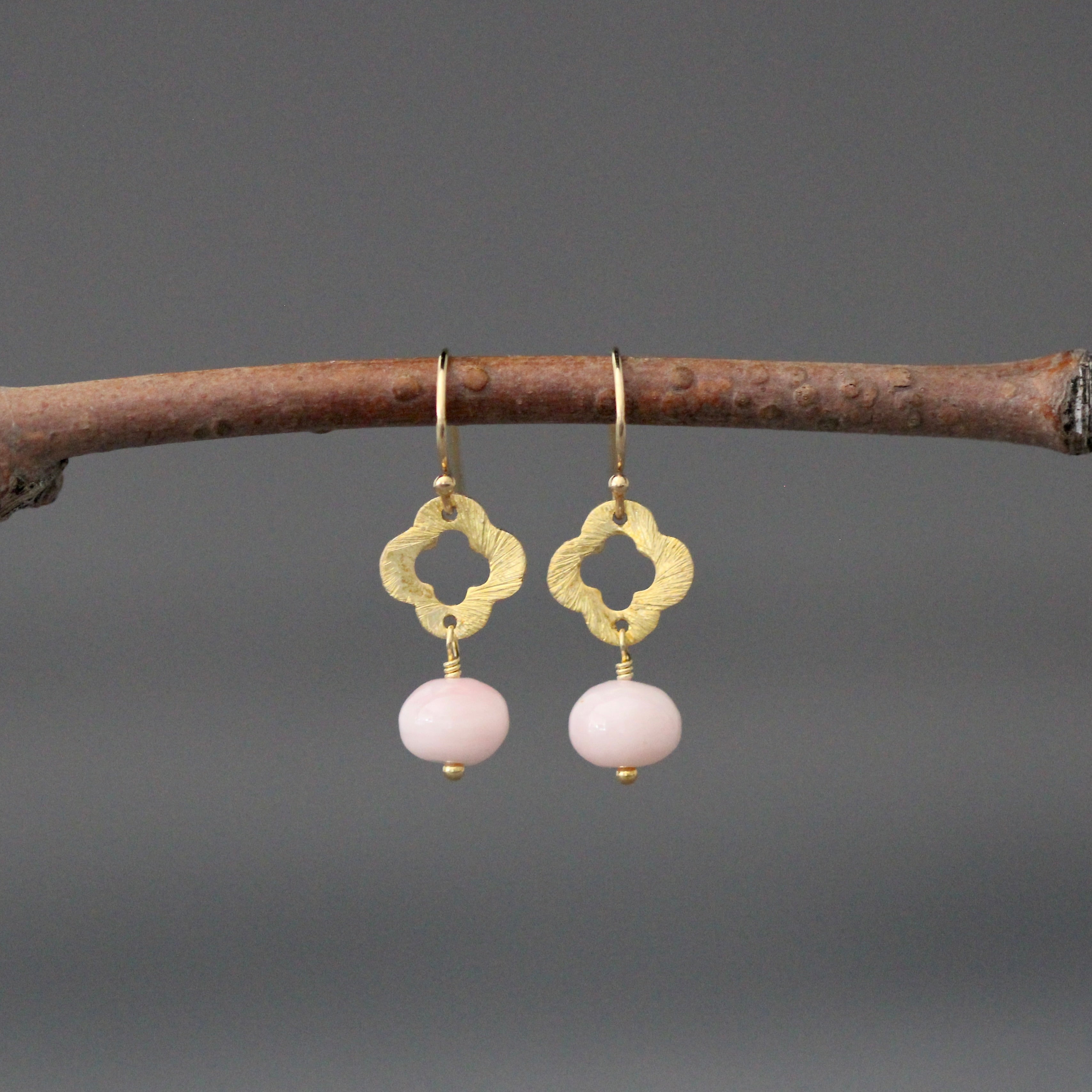Gold drop earrings with clover charm and pink opal bead dangles on hooks