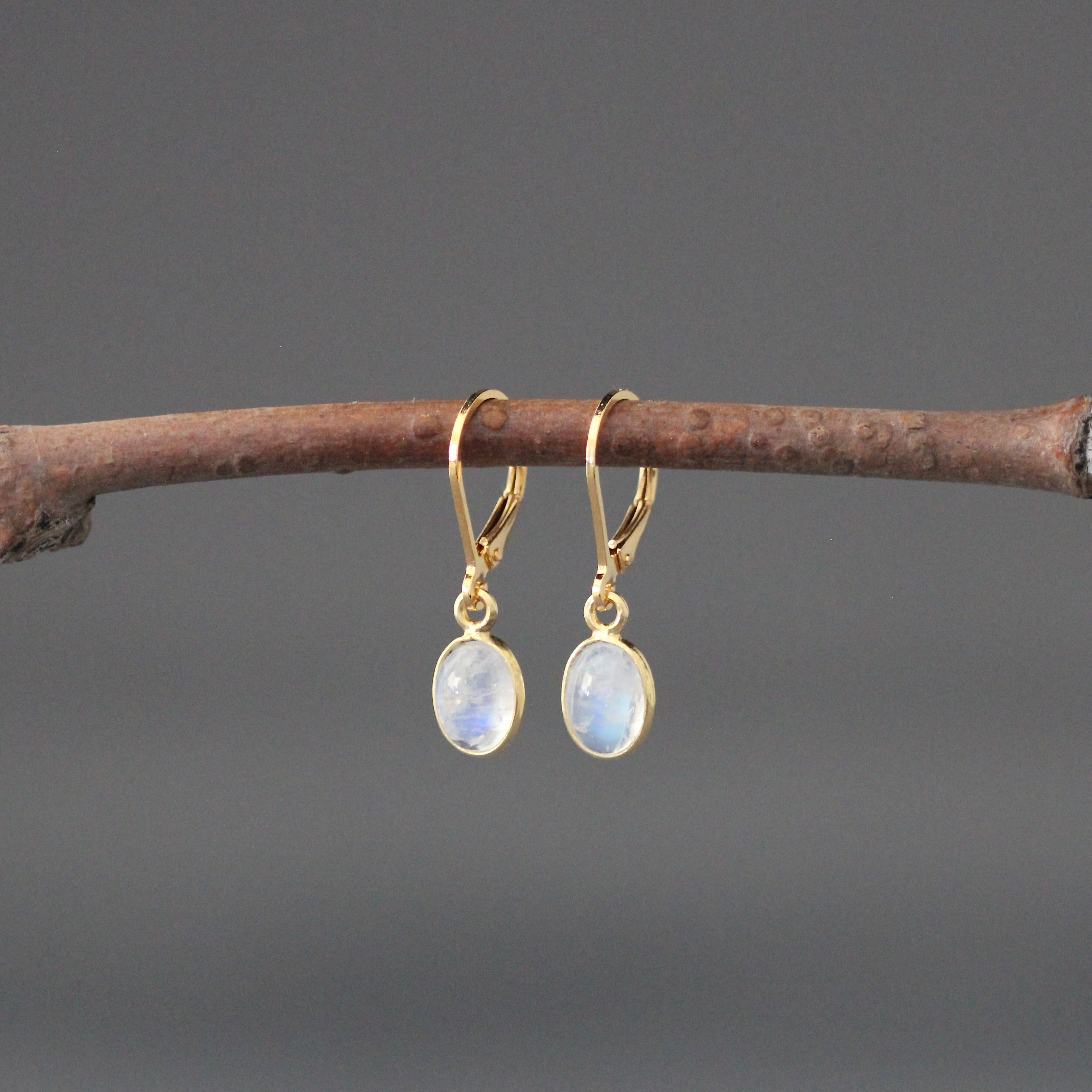 Gold leverback earrings with oval moonstone cabochons, gold bezel drops