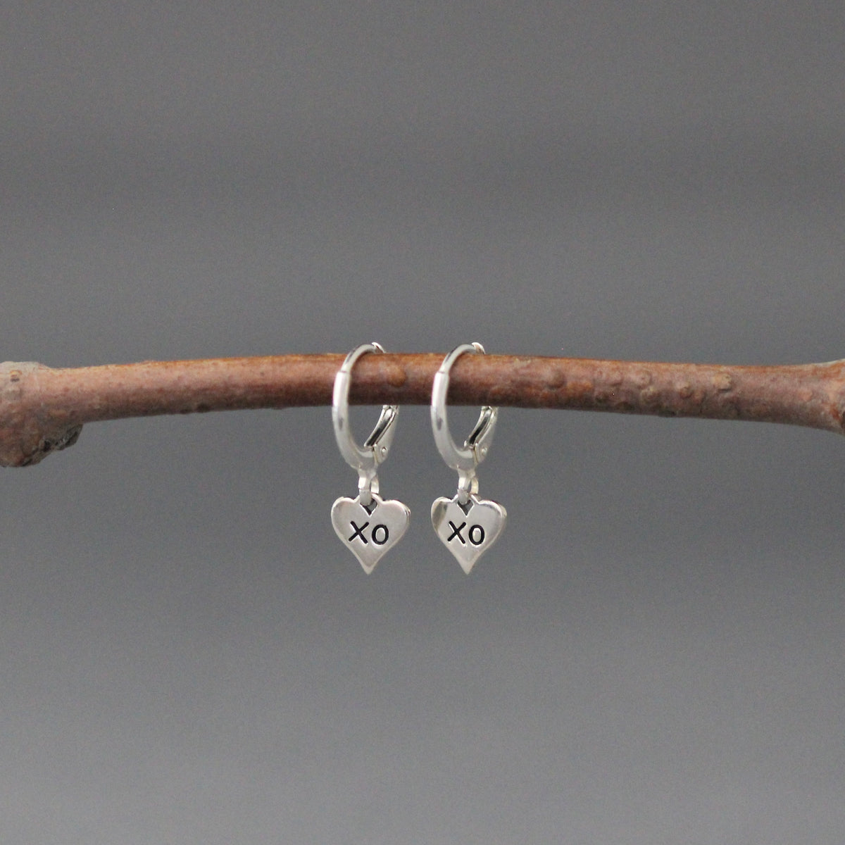 Sterling silver XO heart charm drop earrings on huggie hoops with leverbacks