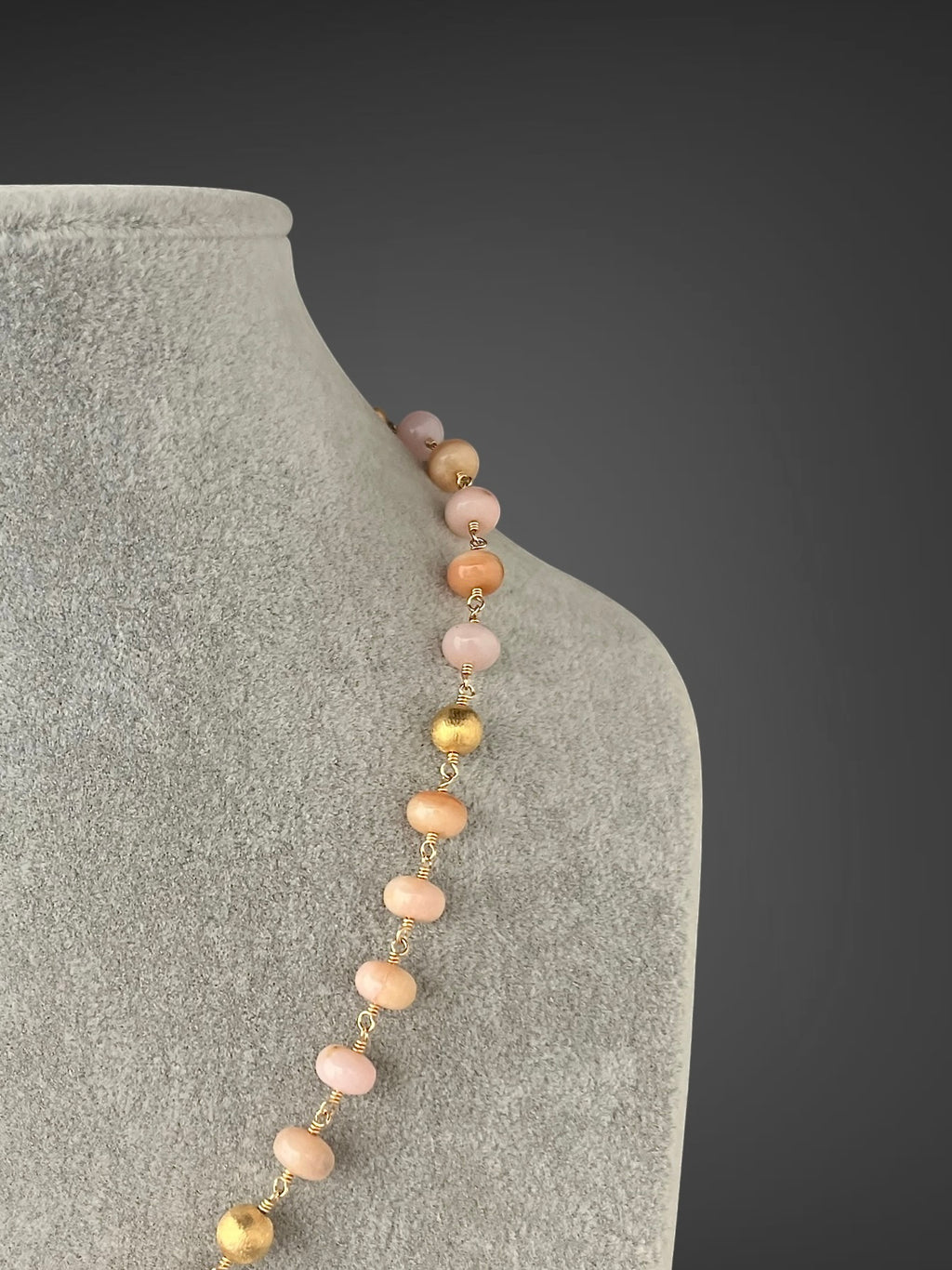 Side view of pink opal bead necklace with small gold station links