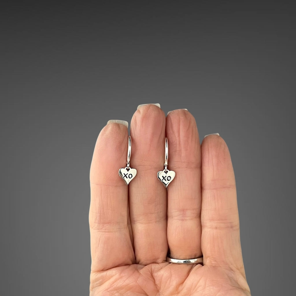 Sterling silver XO heart charm earrings on huggie hoop leverbacks