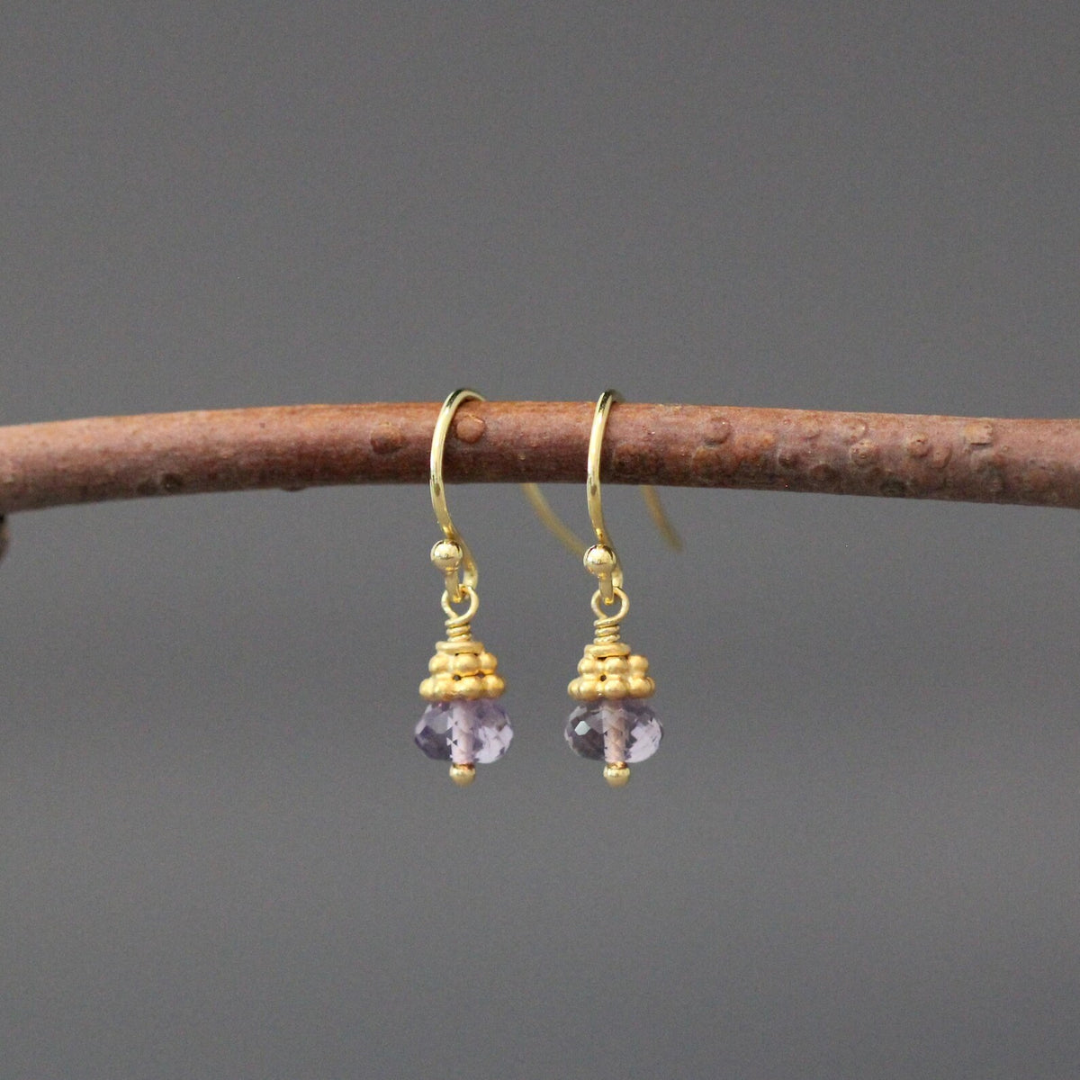 Purple amethyst button drop earrings with gold-tone hoops and dangling bead caps
