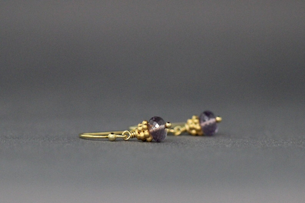 Side view of purple amethyst button drop earrings with gold-tone ear wire and beads