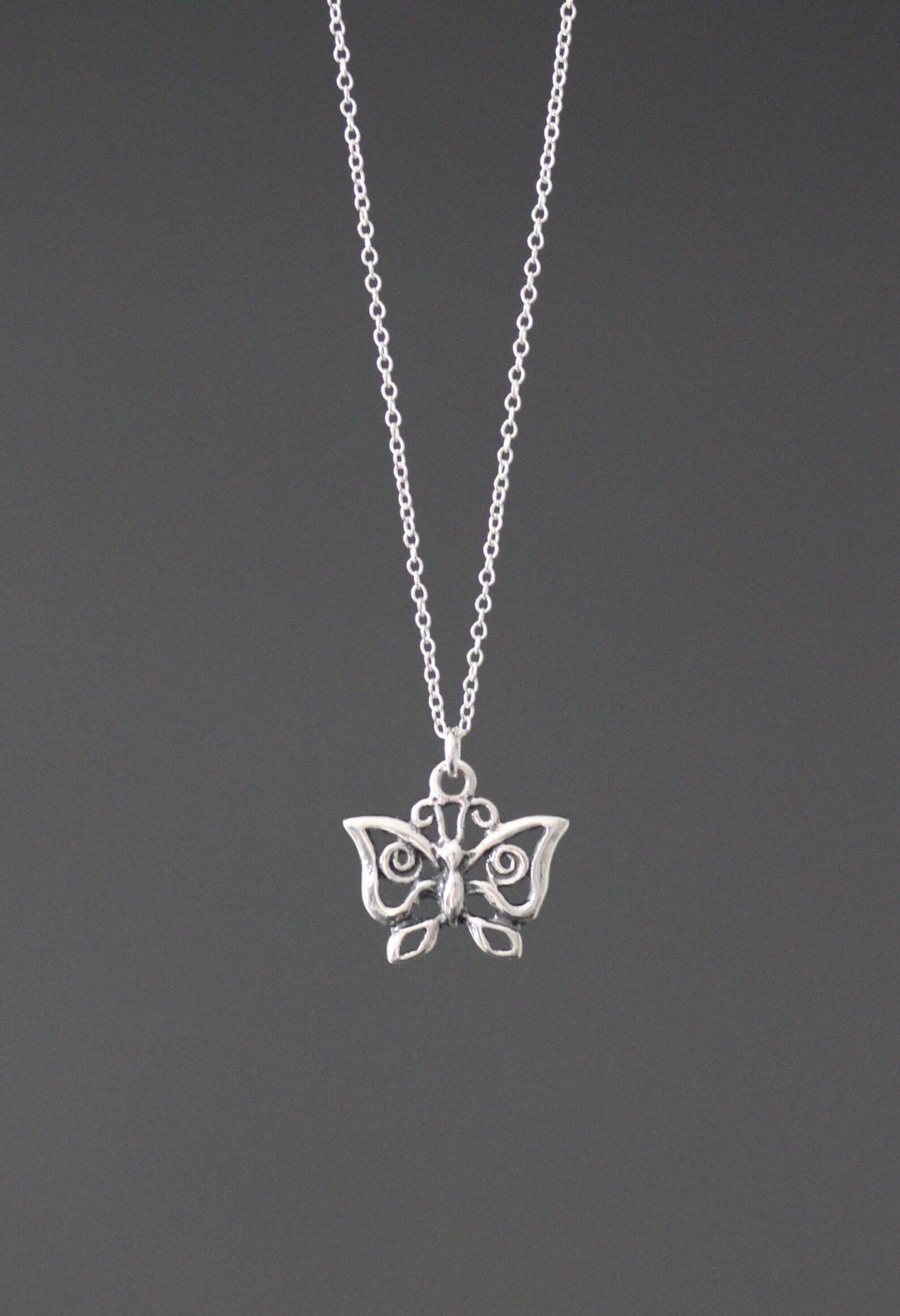 Sterling silver butterfly charm necklace with detailed wing pendant, centered on chain