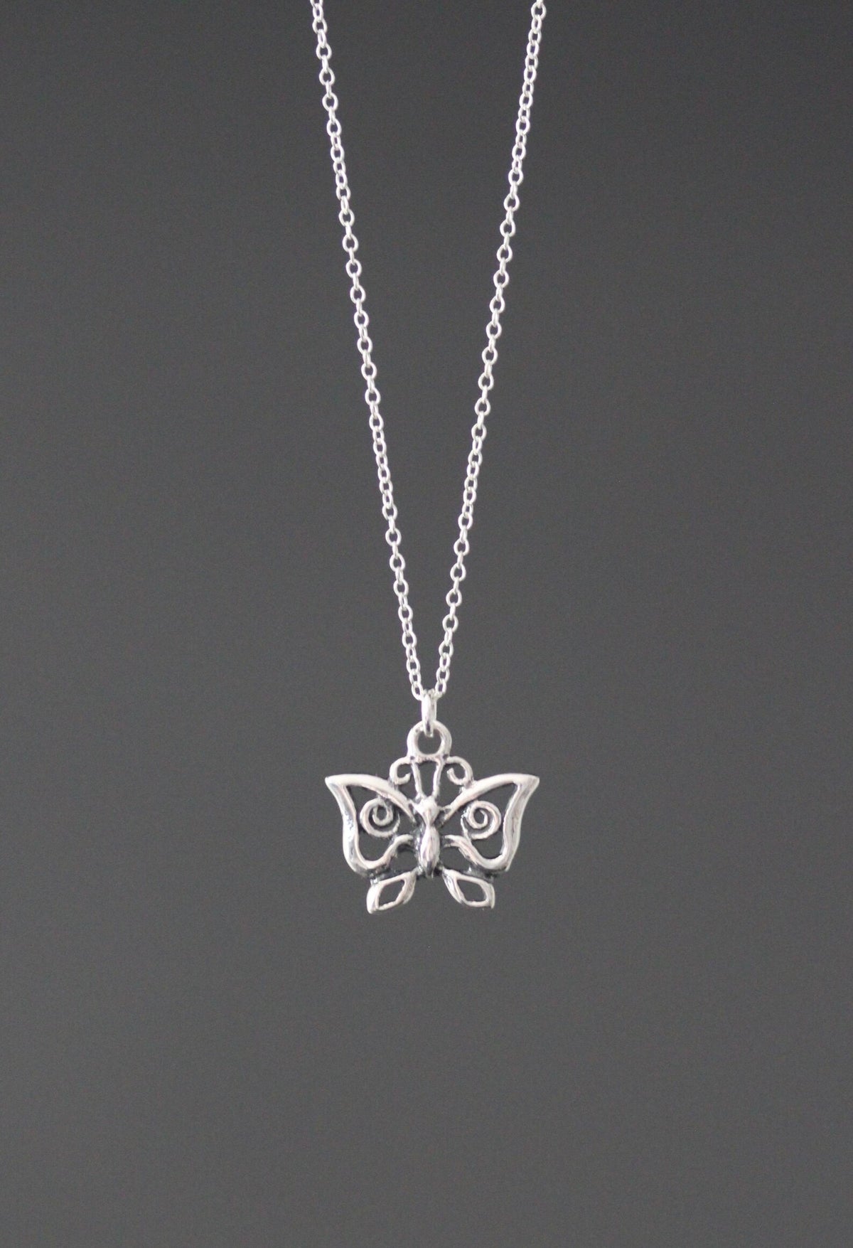 Sterling silver butterfly charm necklace with detailed wing pendant, centered on chain