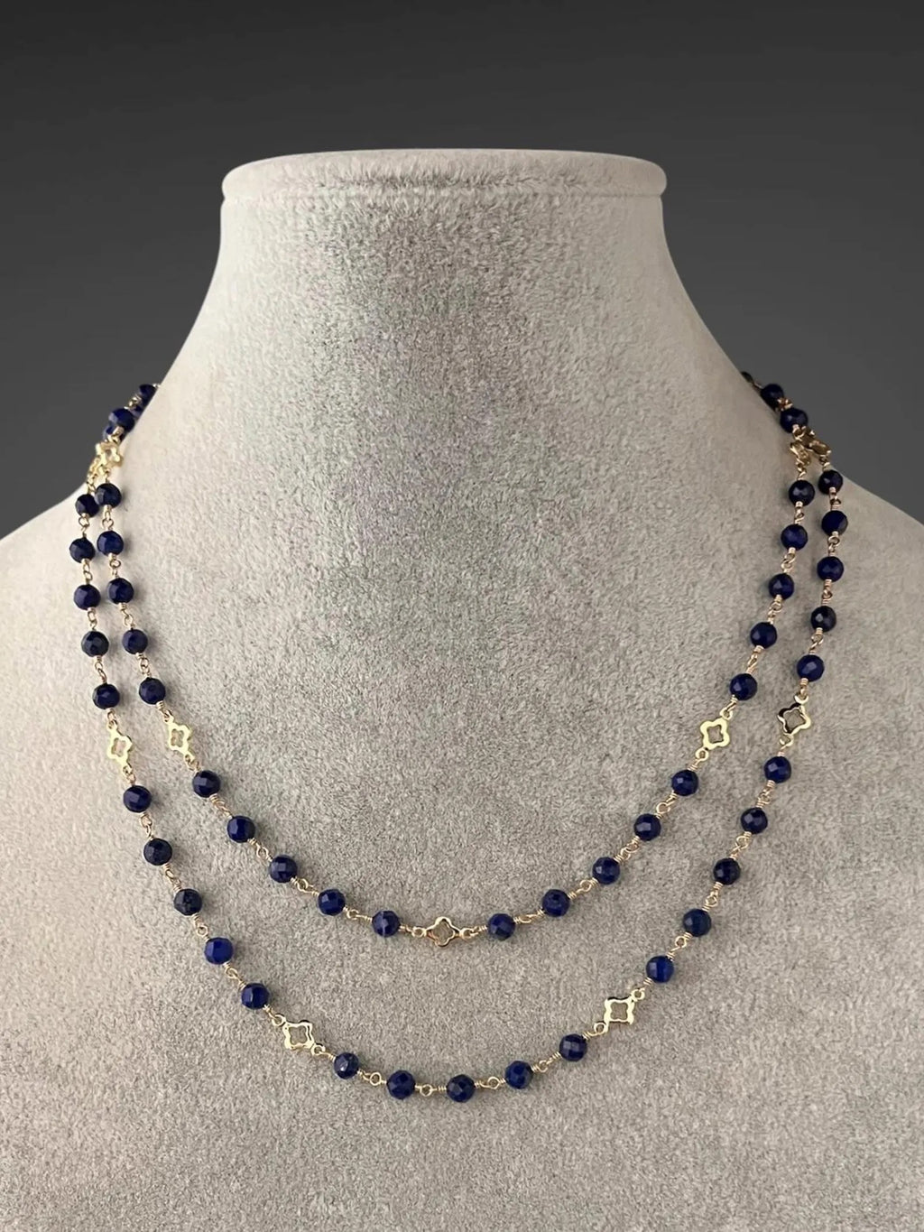 Layered blue lapis bead necklace with gold link accents and small gold connector charms