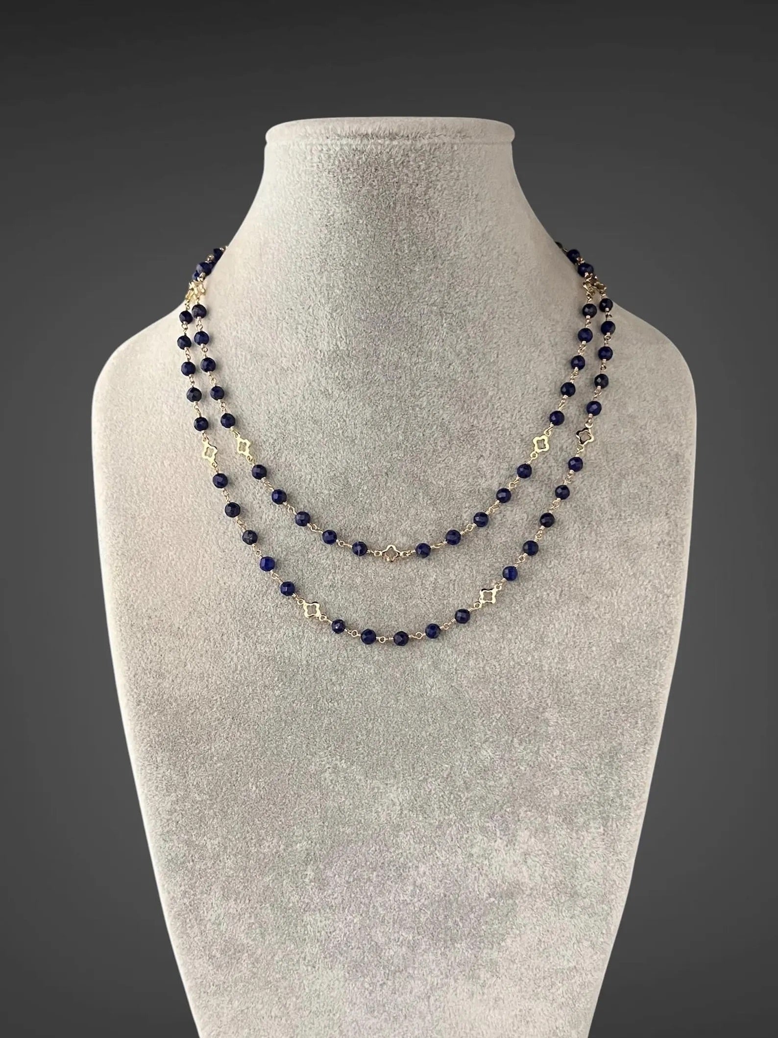 Multi-strand blue lapis beaded necklace with gold connectors and V-shaped center drop