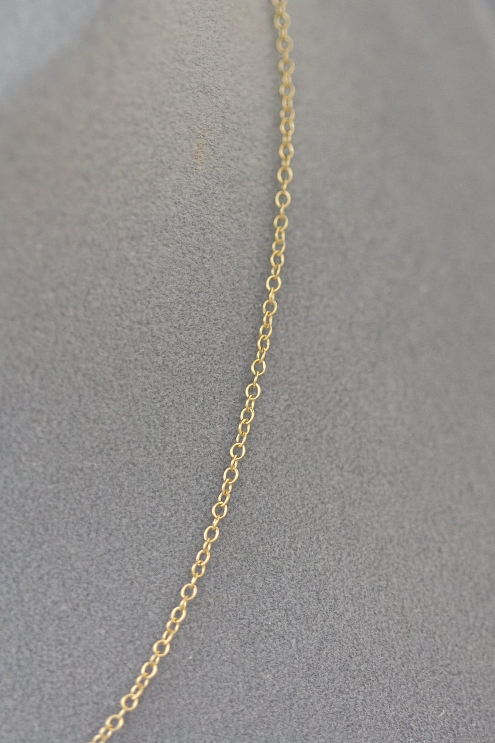 Gold chain necklace on a gray background