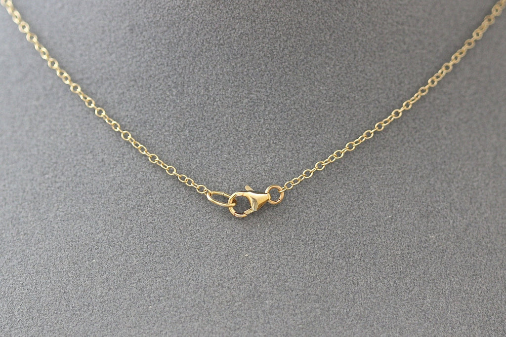 Gold necklace with clasp on a gray background