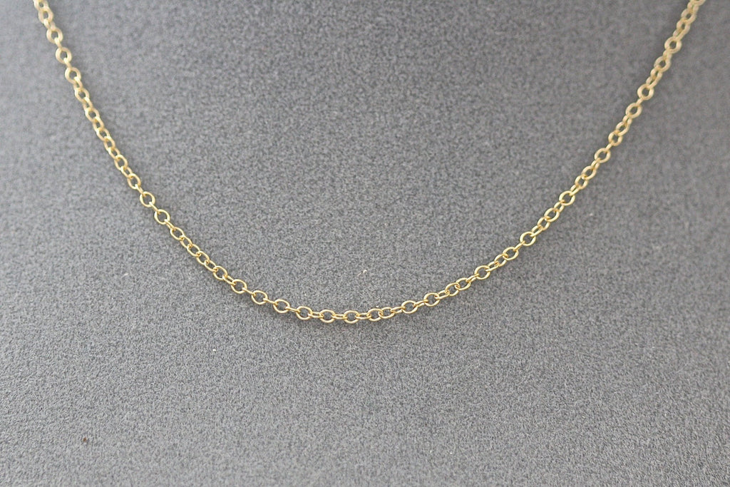 Gold chain necklace on a gray background