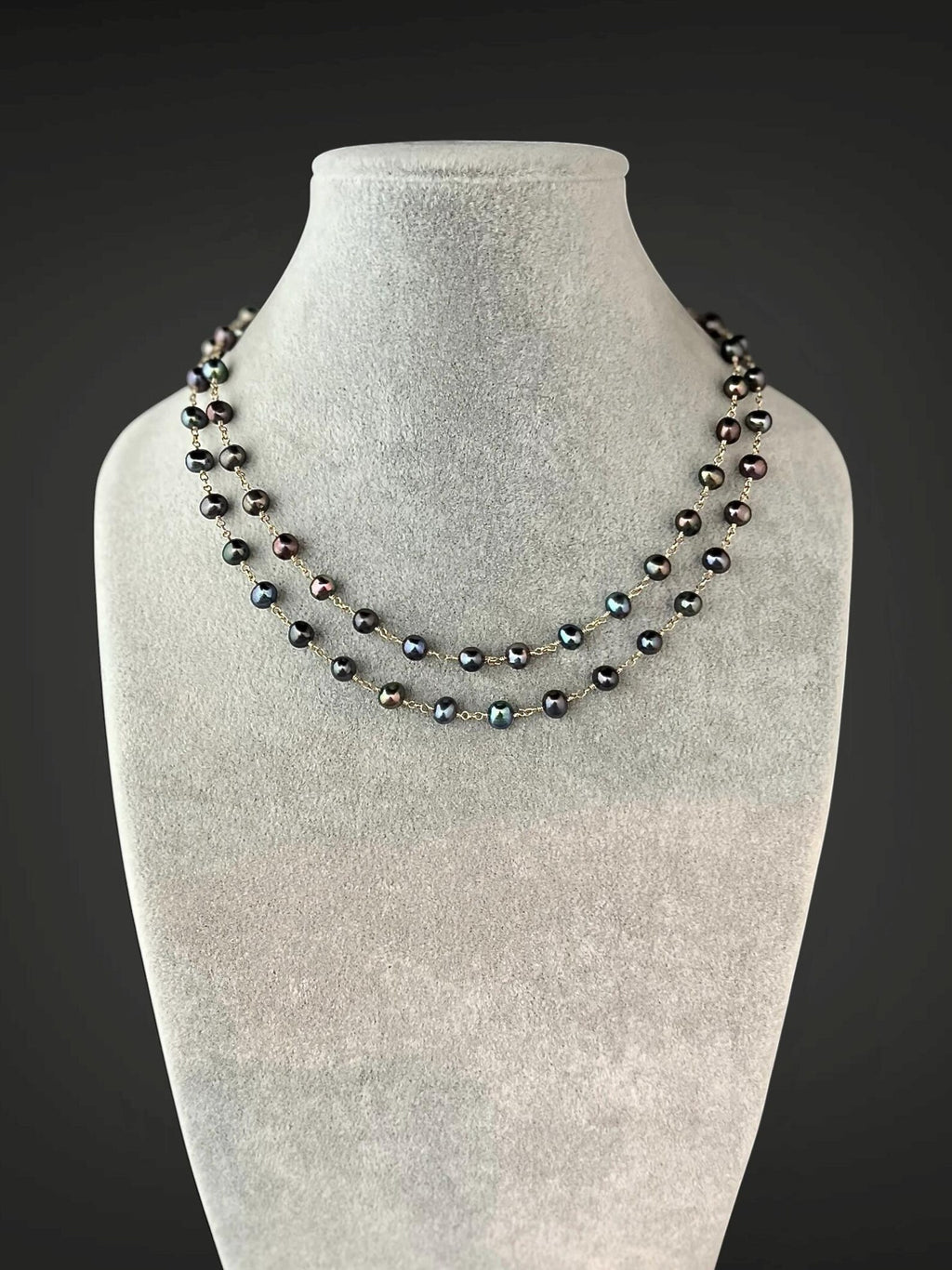 Multi-strand necklace of dark freshwater pearls with gold wire accents, short drape.