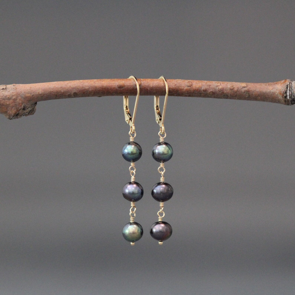 Gold hoop earrings with three dark freshwater pearls, wire-wrapped dangle drops.