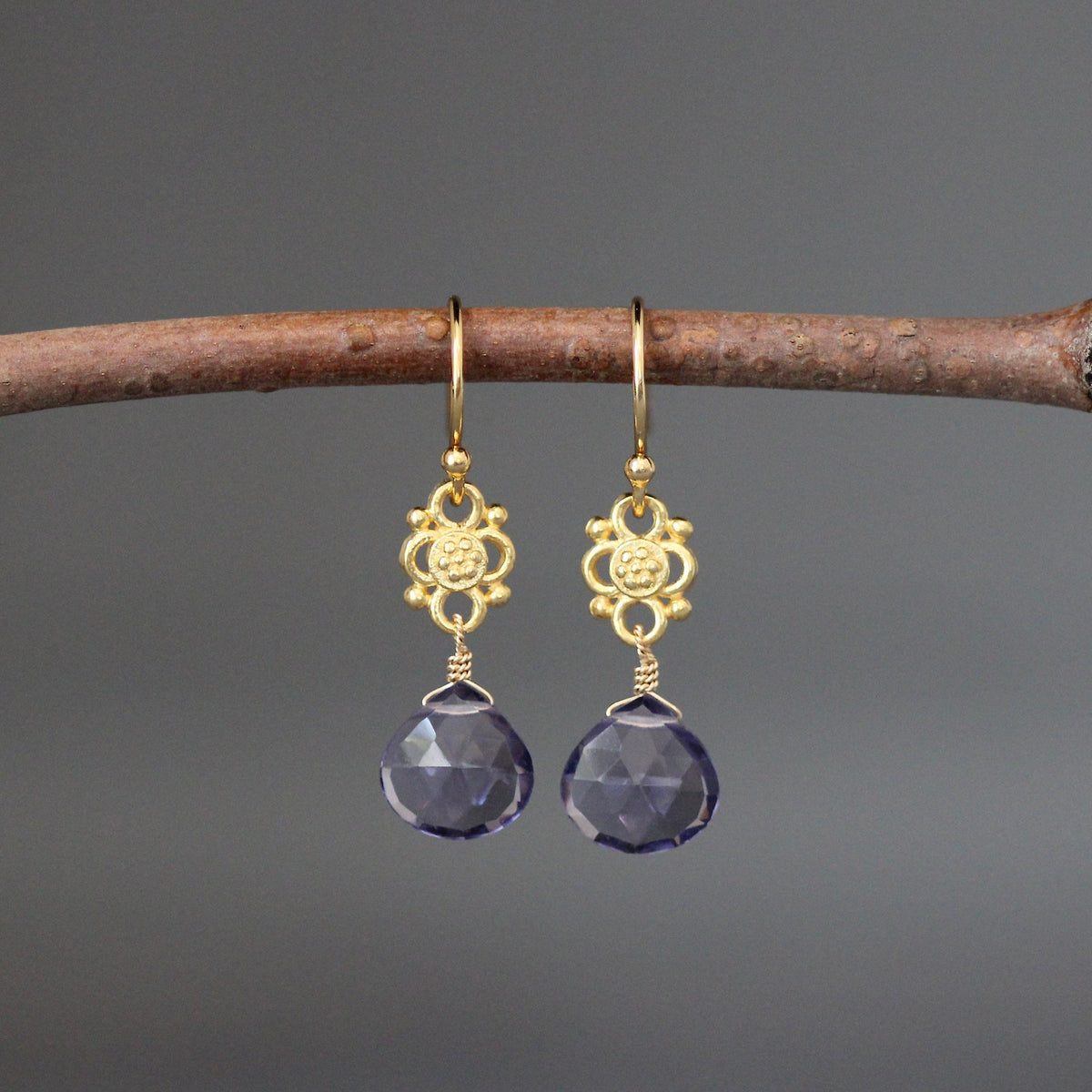 Gold-tone earrings with blue teardrop iolite quartz stones on ornate links