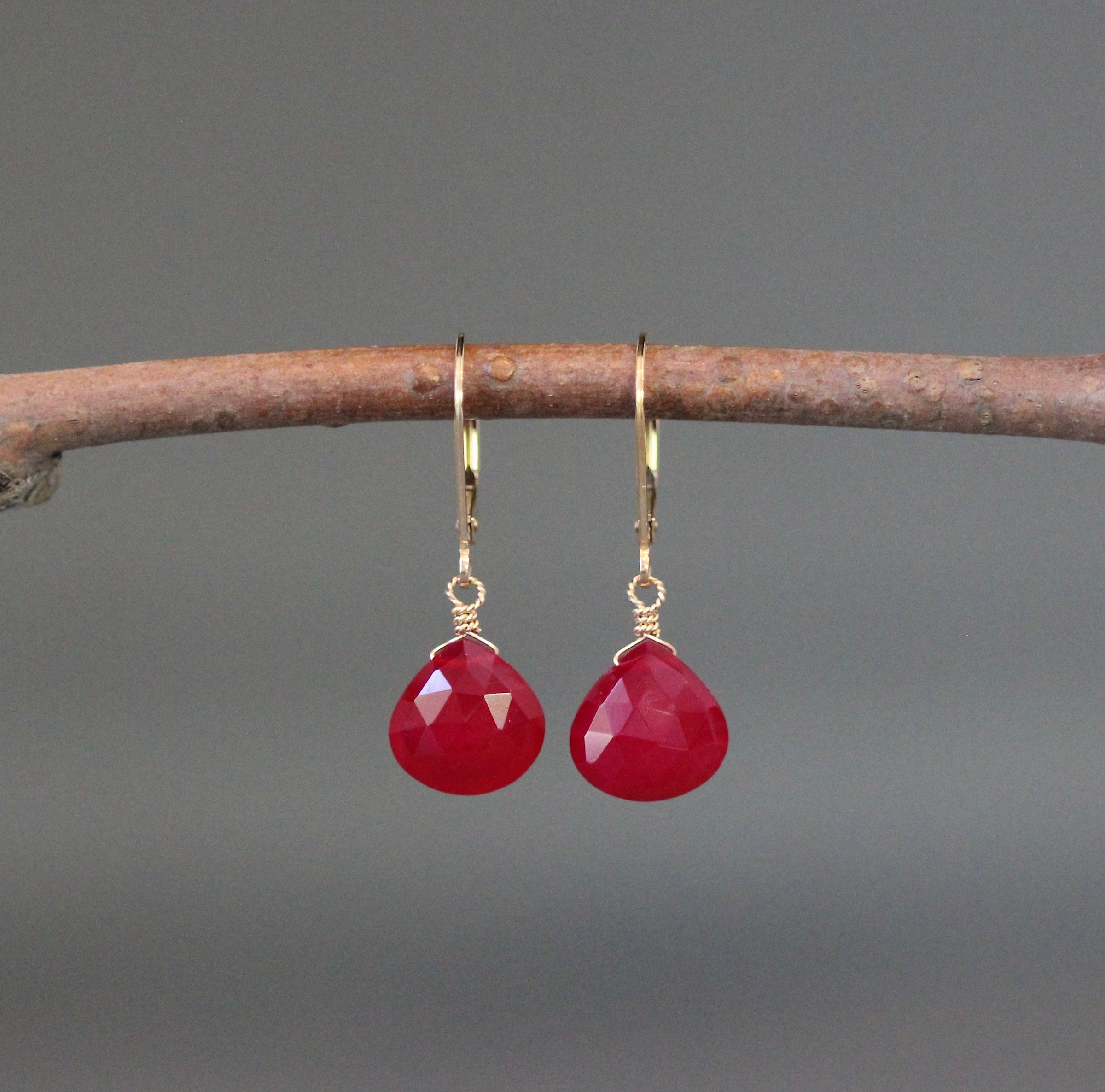 Faceted magenta teardrop earrings with gold leverback hooks, front view