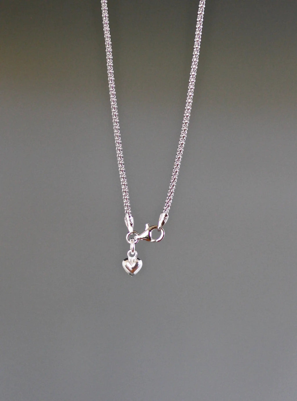Sterling silver chain necklace with small clasp and red oval gemstone pendant