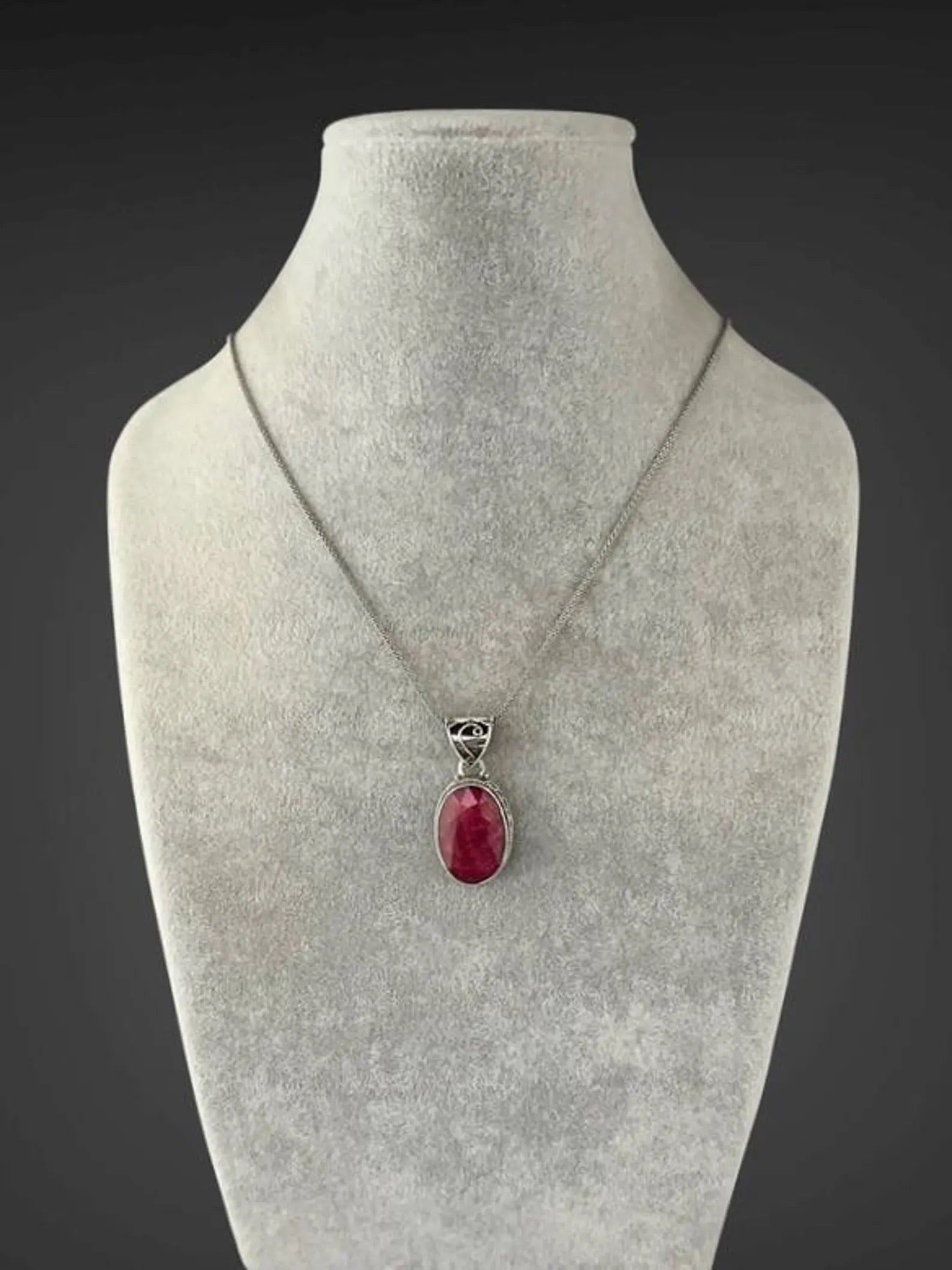 Sterling silver ruby-red oval pendant necklace on mannequin bust