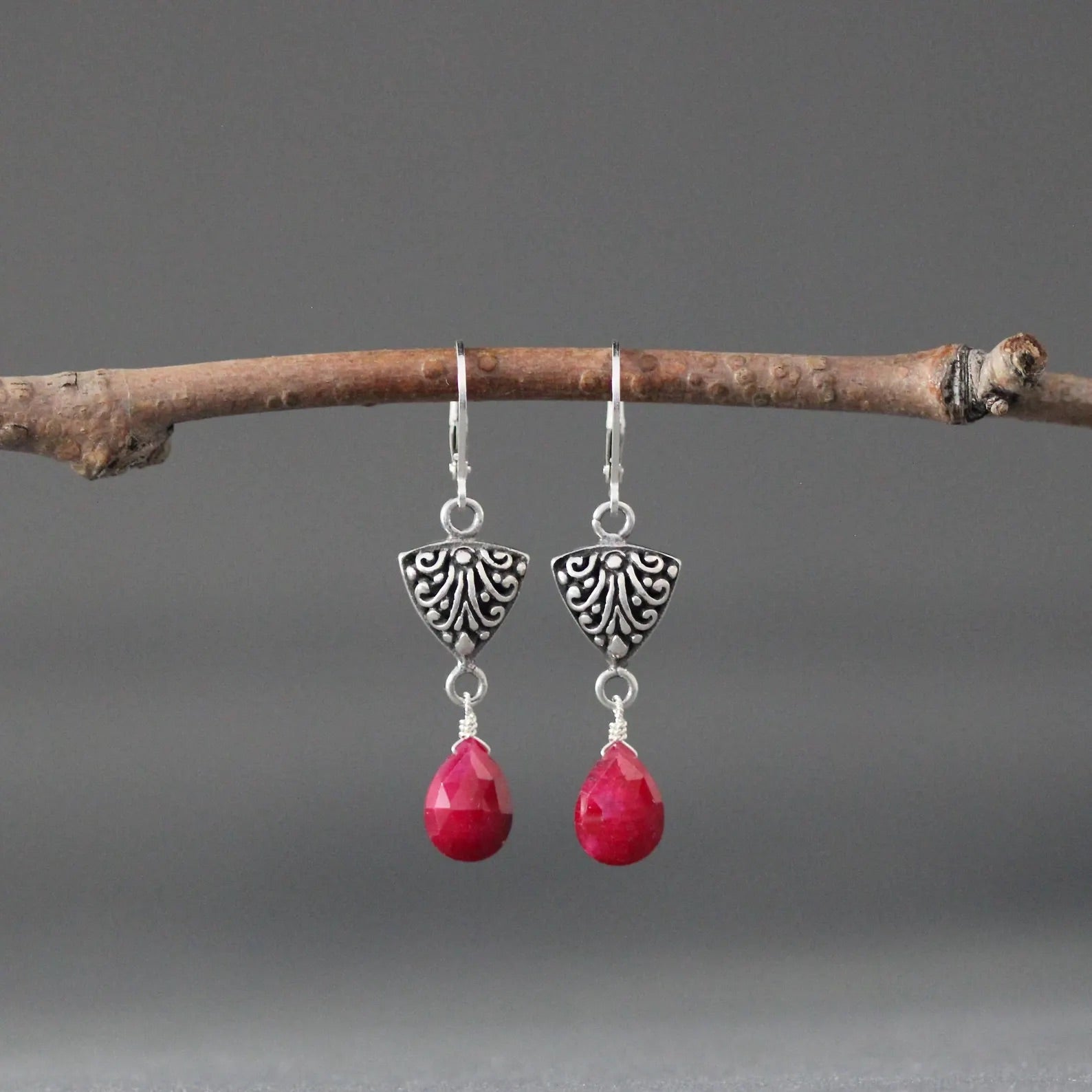 Silver teardrop earrings with ornate Bali-style caps and red ruby teardrop drops
