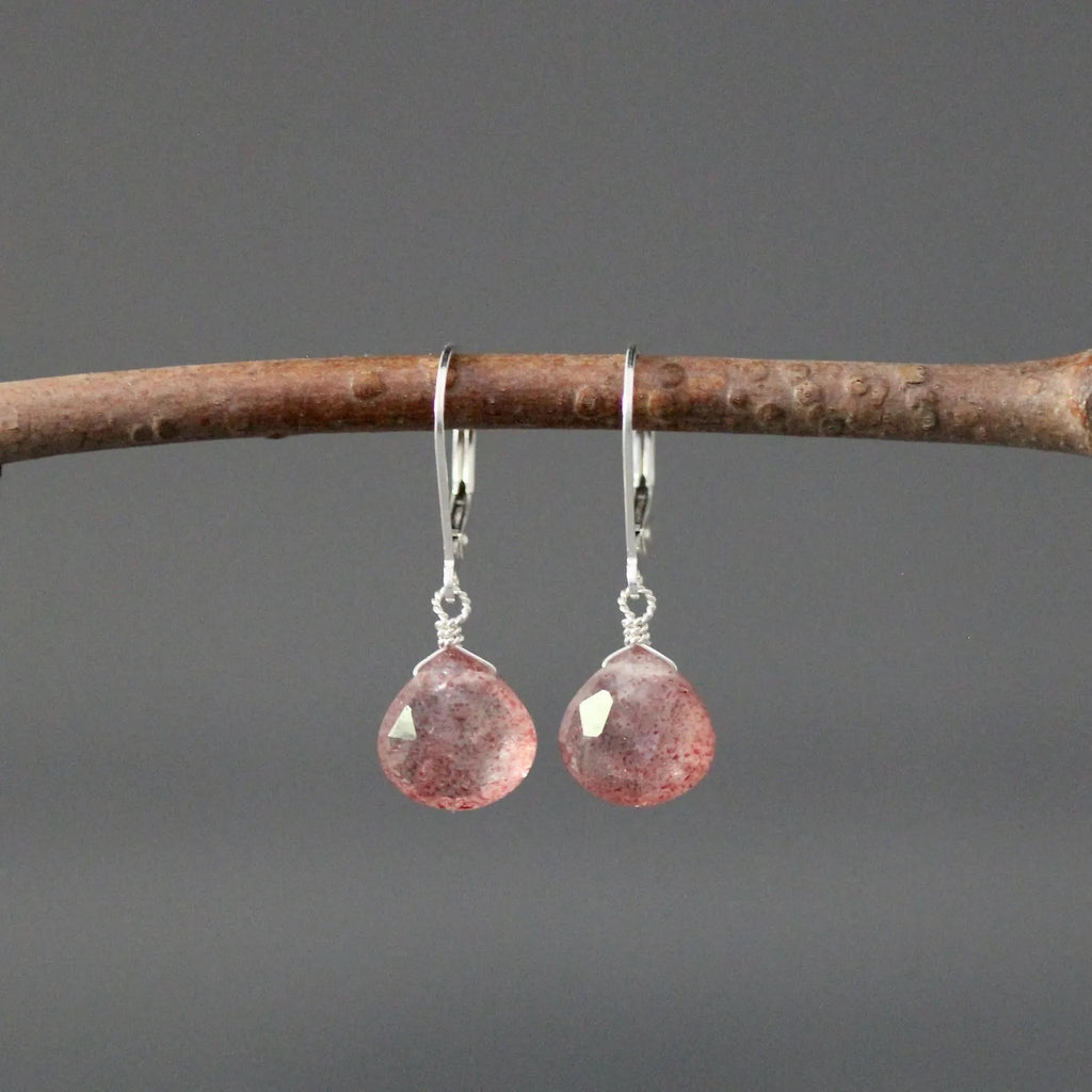Strawberry quartz and silver earrings against a gray backdrop