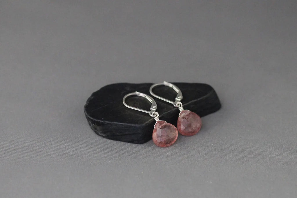 Strawberry quartz and silver earrings against a gray backdrop
